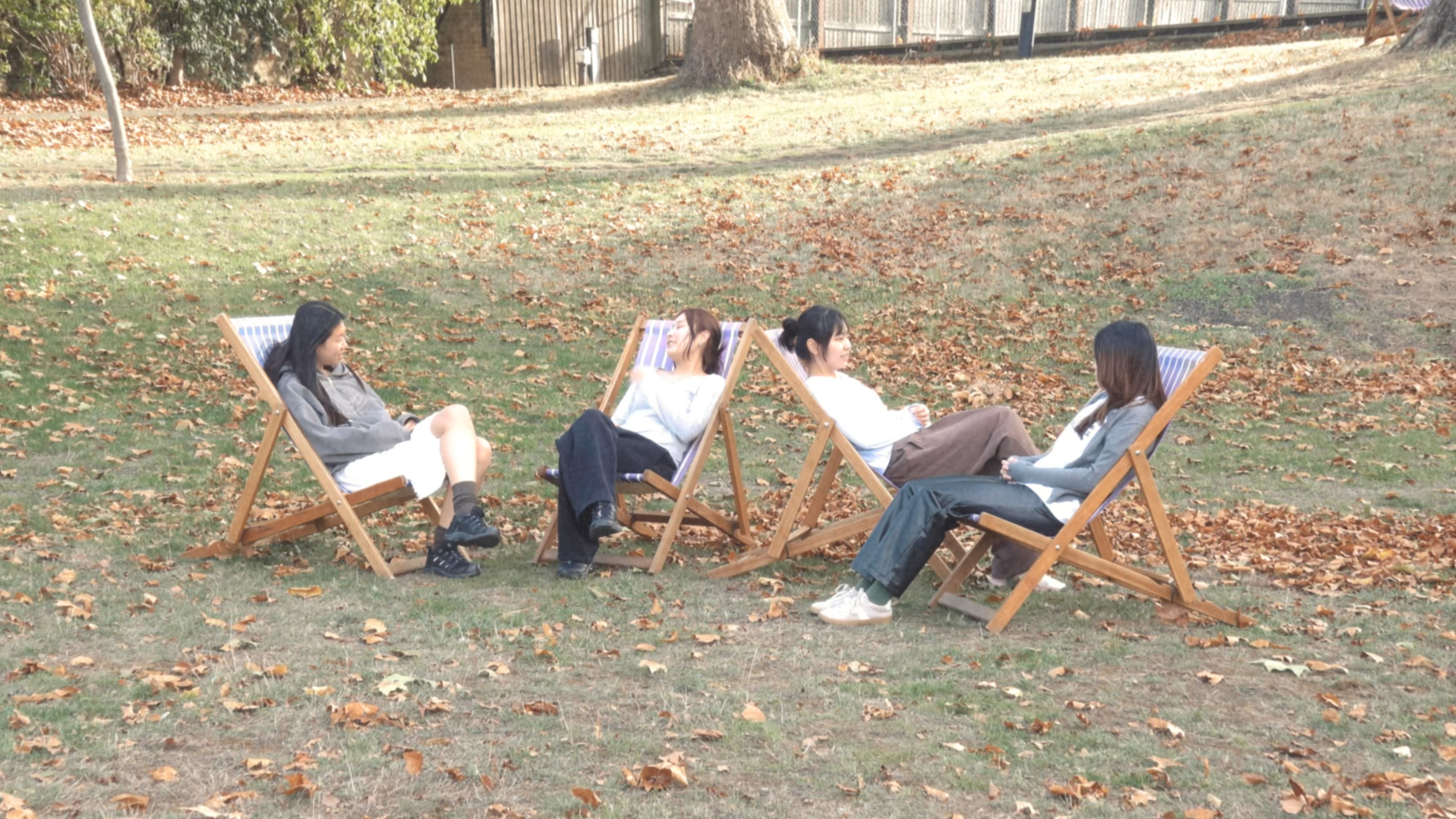 Four people sitting in deckchairs outdoors in a still from To Sense
